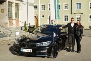 Geschäftsführer-Paar vor ihren eigenen Taxis